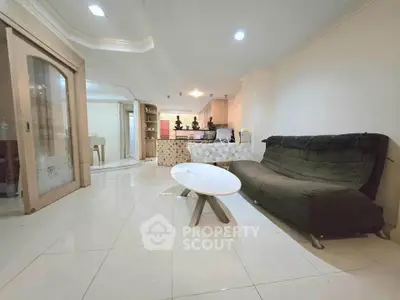 Spacious living room with modern decor and open kitchen layout, perfect for entertaining guests.