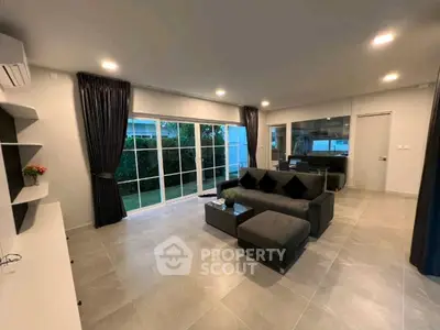 Spacious modern living room with large windows and garden view