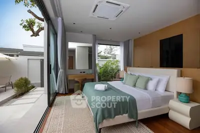 Luxurious modern bedroom with large windows and garden view, featuring elegant decor and spacious layout.