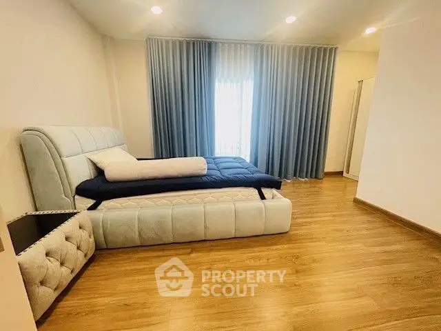 Spacious bedroom with elegant bed and floor-to-ceiling curtains