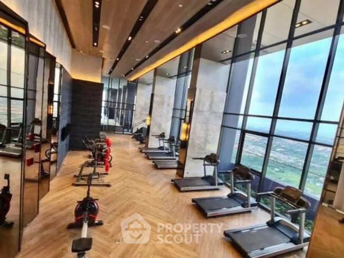 Luxurious high-rise gym with panoramic city views and modern equipment.