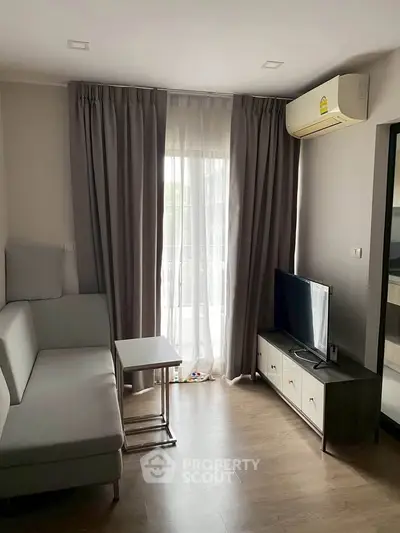 Cozy living room with modern sofa and TV, featuring elegant curtains and air conditioning.