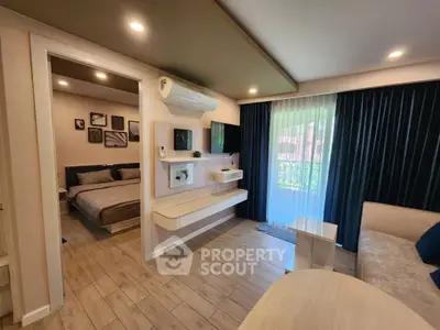 Modern living room with open view to bedroom, featuring stylish decor and natural light.