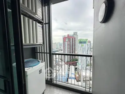 High-rise apartment balcony with city skyline view and washing machine.