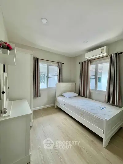 Bright and cozy bedroom with single bed and air conditioning, perfect for a serene living experience.