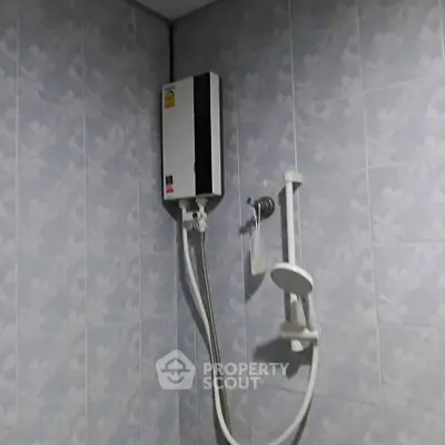 Modern bathroom with sleek shower unit and tiled walls, perfect for a refreshing experience.