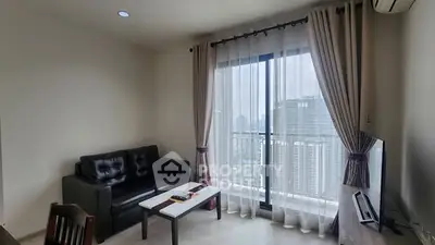 Modern living room with city view and balcony access in high-rise apartment.