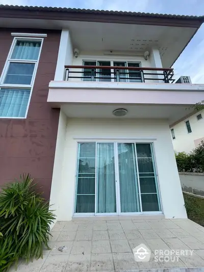 Modern two-story house with balcony and sliding glass doors