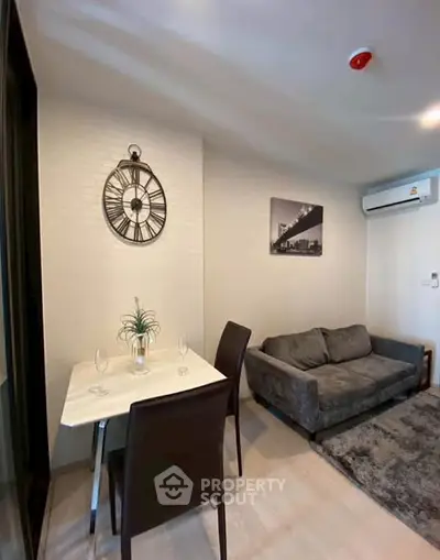 Modern living room with cozy sofa, dining table, and stylish wall clock in a contemporary apartment.