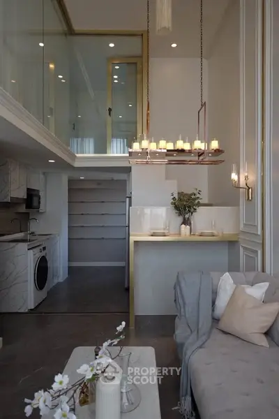Luxurious modern living room with mezzanine, elegant chandelier, and stylish decor in a sophisticated apartment.