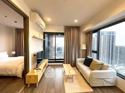 Modern living room with city view, featuring cozy sofa and wooden accents, adjacent to a stylish bedroom.