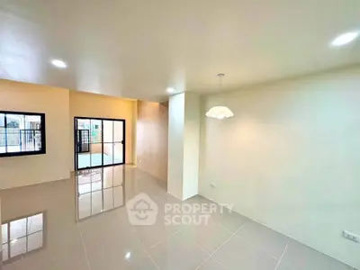 Spacious modern living room with glossy tiled floors and ample natural light.