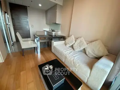 Modern living room with cozy sofa, dining table, and sleek kitchen in open layout apartment.