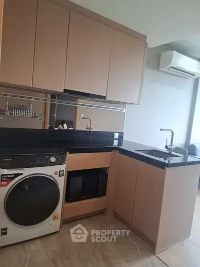 Modern kitchen with sleek cabinetry, integrated appliances, and stylish black countertops.