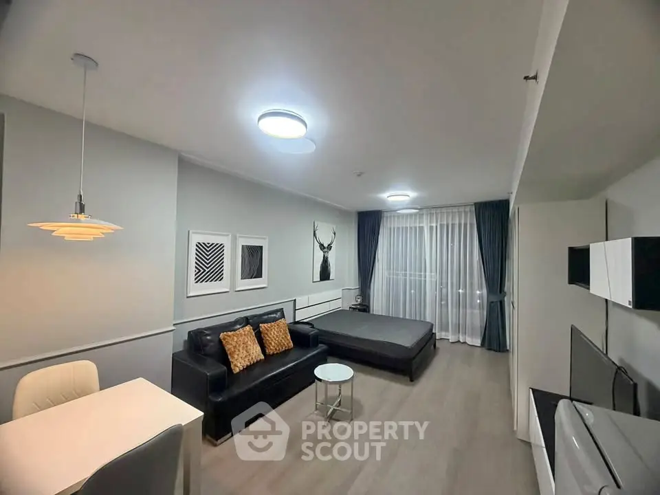 Modern studio apartment with stylish decor and open layout, featuring a cozy living area and large windows.
