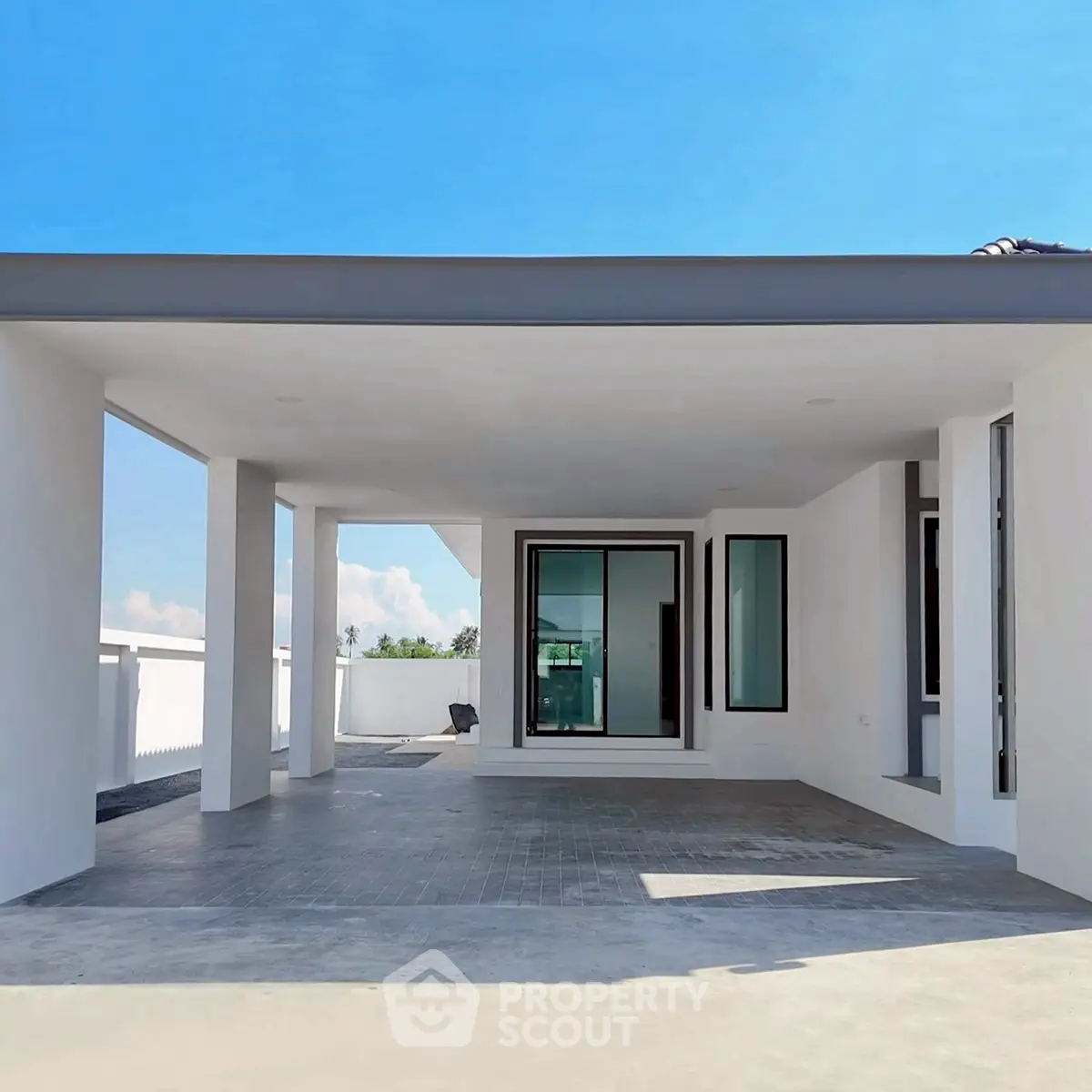 Modern minimalist house exterior with spacious covered patio and sleek design.