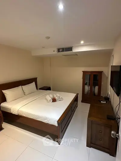 Spacious bedroom with elegant wooden furniture and modern amenities