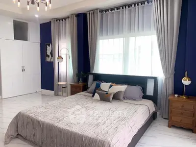 Spacious bedroom with elegant decor and large windows for natural light.