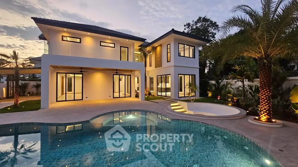 Luxurious modern villa with stunning pool and elegant exterior lighting at dusk.