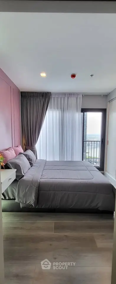 Modern bedroom with balcony view, featuring elegant decor and ample natural light.