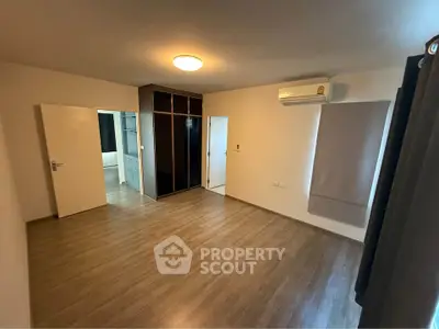 Spacious bedroom with wooden flooring and built-in wardrobe