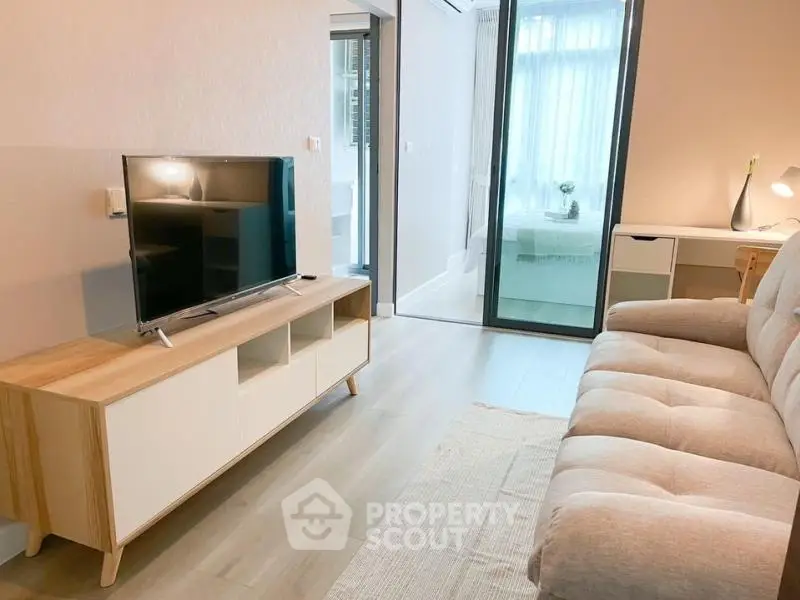 Modern living room with cozy sofa and sleek TV unit, bright and inviting space.