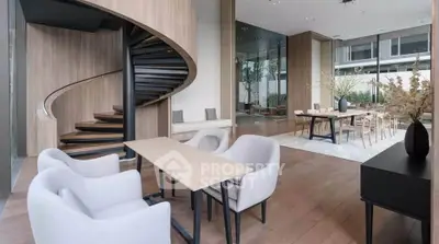 Luxurious modern interior with elegant spiral staircase and stylish dining area, perfect for sophisticated living.