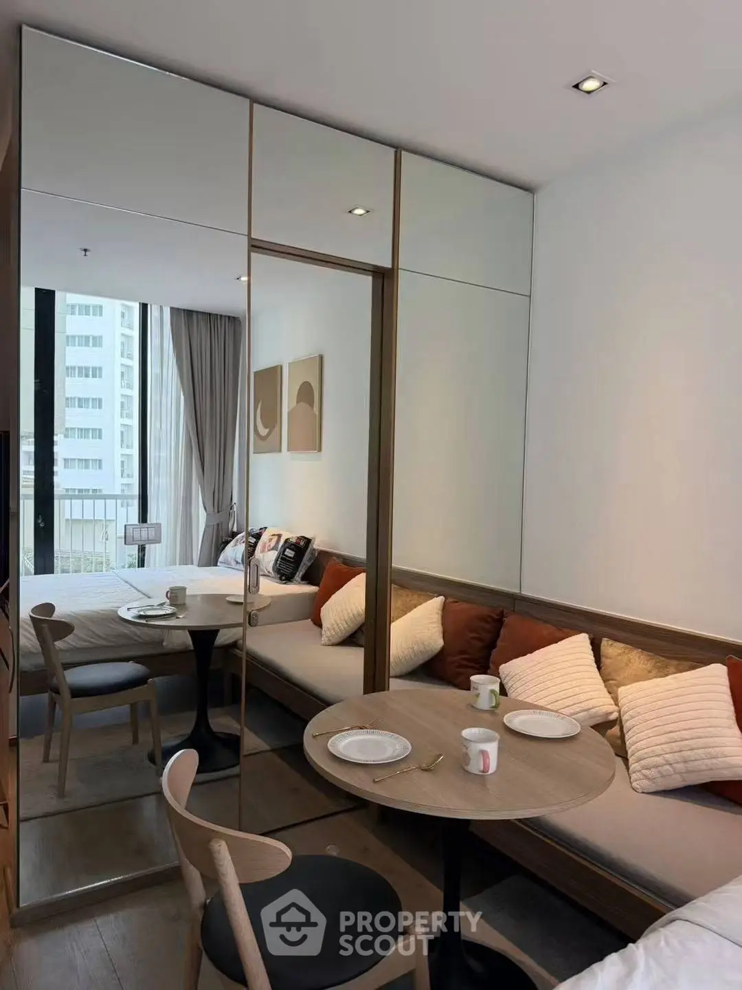 Modern living room with cozy seating and mirrored wardrobe, perfect for urban living.