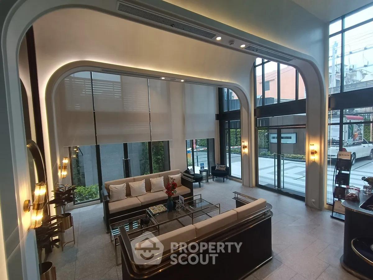 Luxurious modern living room with high ceilings and large windows offering a stunning view.