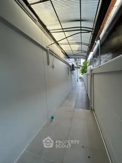 Spacious covered walkway with tiled flooring and modern design