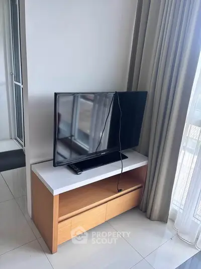 Modern living room with sleek TV stand and large window for natural light.
