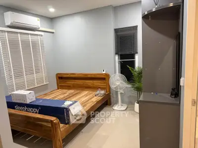 Cozy bedroom with wooden bed frame, air conditioning, and modern decor