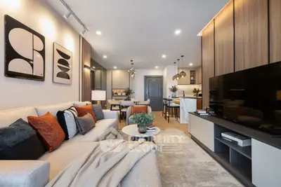Modern living room with cozy seating and stylish decor in open-plan apartment.