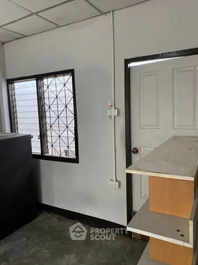 Cozy storage room with window and shelving, ideal for organizing household items.