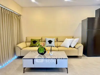 Modern living room with beige sofa, stylish coffee table, and sleek refrigerator in a cozy setting.