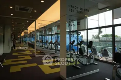 Modern gym with exercise bikes and mirrored walls in a luxury apartment building.