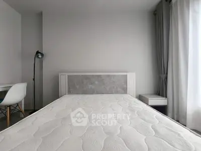 Modern minimalist bedroom with stylish decor and natural light, featuring a comfortable bed and elegant furnishings.