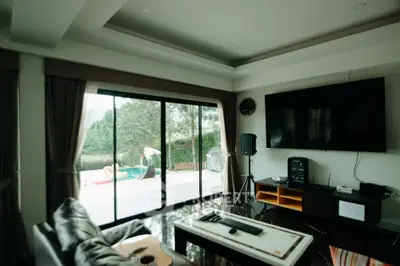 Spacious living room with pool view and entertainment setup