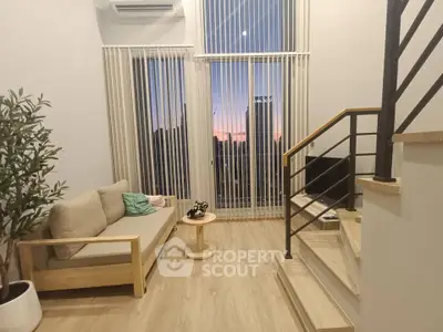 Modern living room with sunset view, featuring stylish furniture and large windows for natural light.