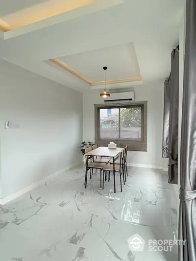 Modern dining area with elegant marble flooring and stylish lighting