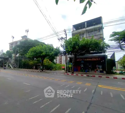 Street view of urban building with trees and clear road