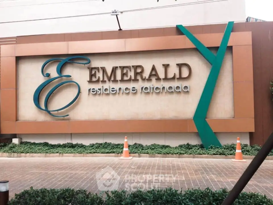 Emerald Residence Ratchada entrance sign with modern design and lush greenery.