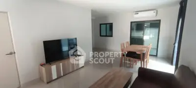 Spacious living room with modern furniture and dining area in a bright apartment.