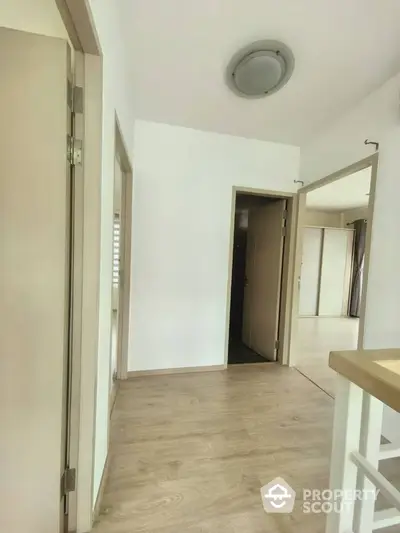 Bright hallway with wooden flooring and modern light fixture