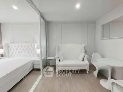 Elegant white bedroom with plush bed and stylish seating area