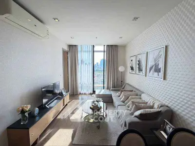 Modern living room with city view, stylish decor, and ample natural light in a high-rise apartment.