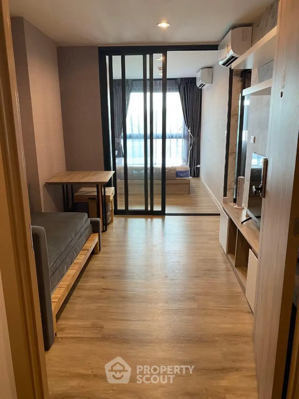 Modern apartment interior with sliding glass doors and wooden flooring