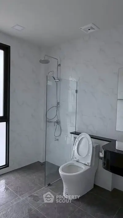 Modern bathroom with glass shower and sleek fixtures in a contemporary home.