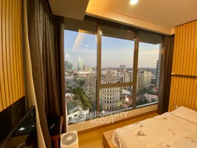 Luxurious bedroom with stunning city view through large windows, featuring modern decor and cozy ambiance.