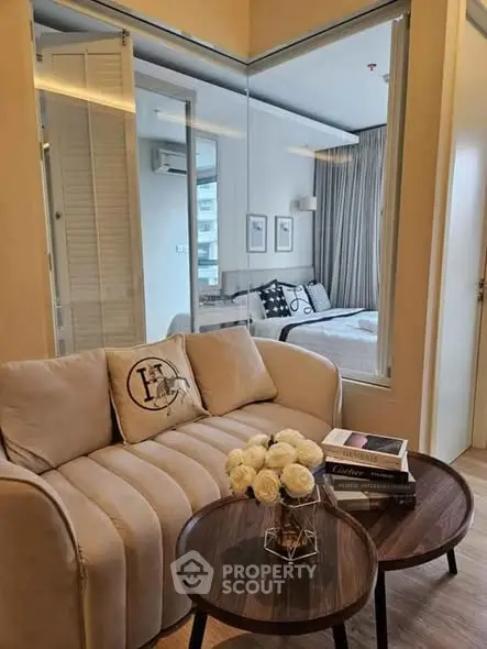 Modern living room with cozy sofa and stylish decor leading to a chic bedroom.